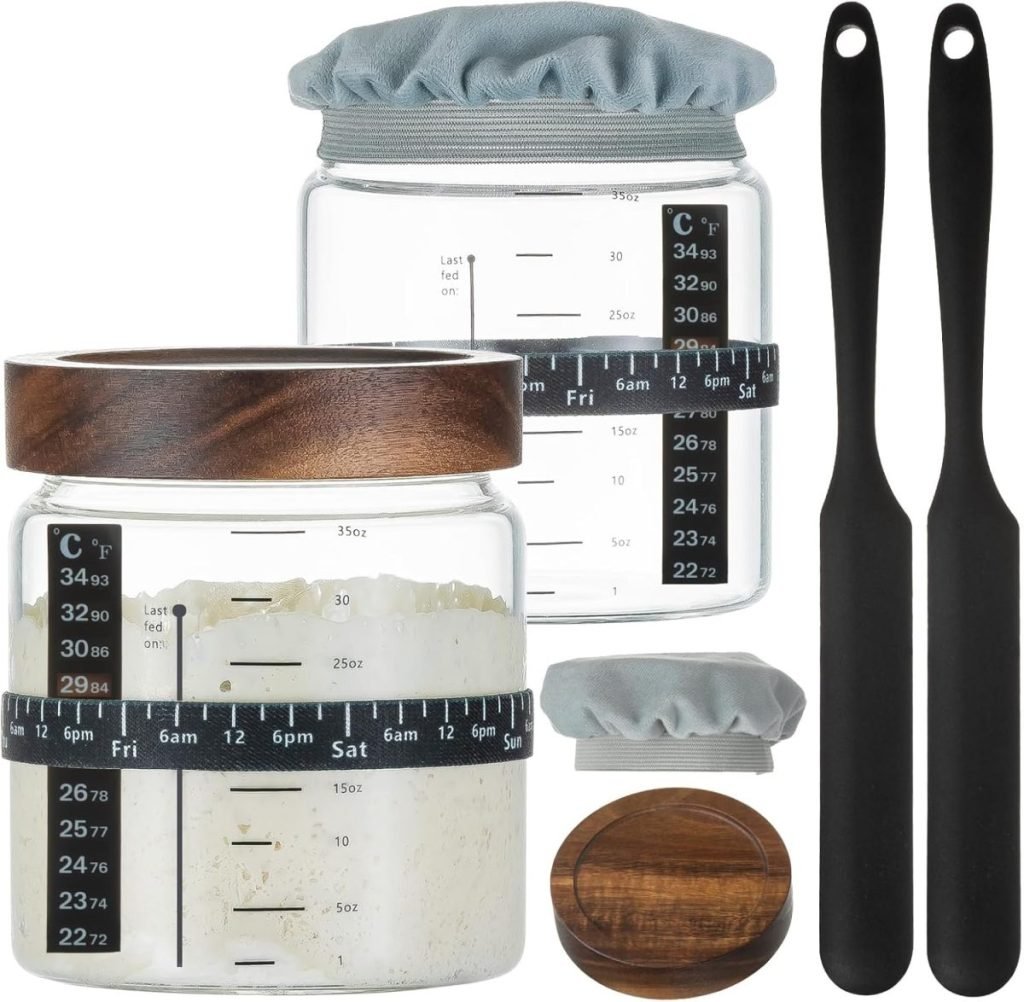 Glass jars with measurement markings, wooden lids, two cloth covers, and two black spatulas.