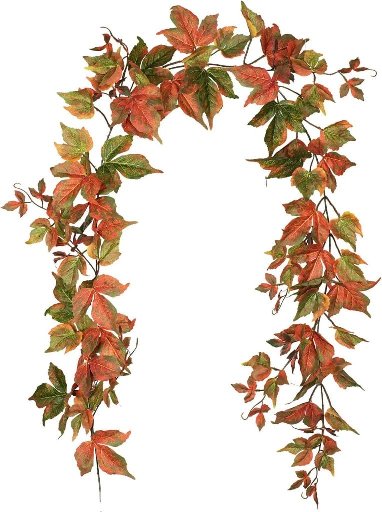 A decorative garland of fall foliage featuring green, orange, and red leaves arranged in an arch.