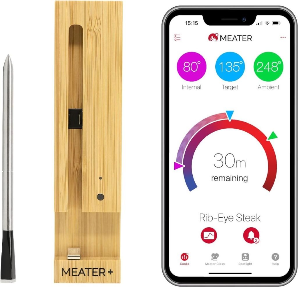 A digital meat thermometer with a wooden charging dock sits elegantly next to a smartphone, displaying rib-eye steak's cooking temperature and time information. Available on Amazon Prime, it offers convenience and precision for culinary enthusiasts.