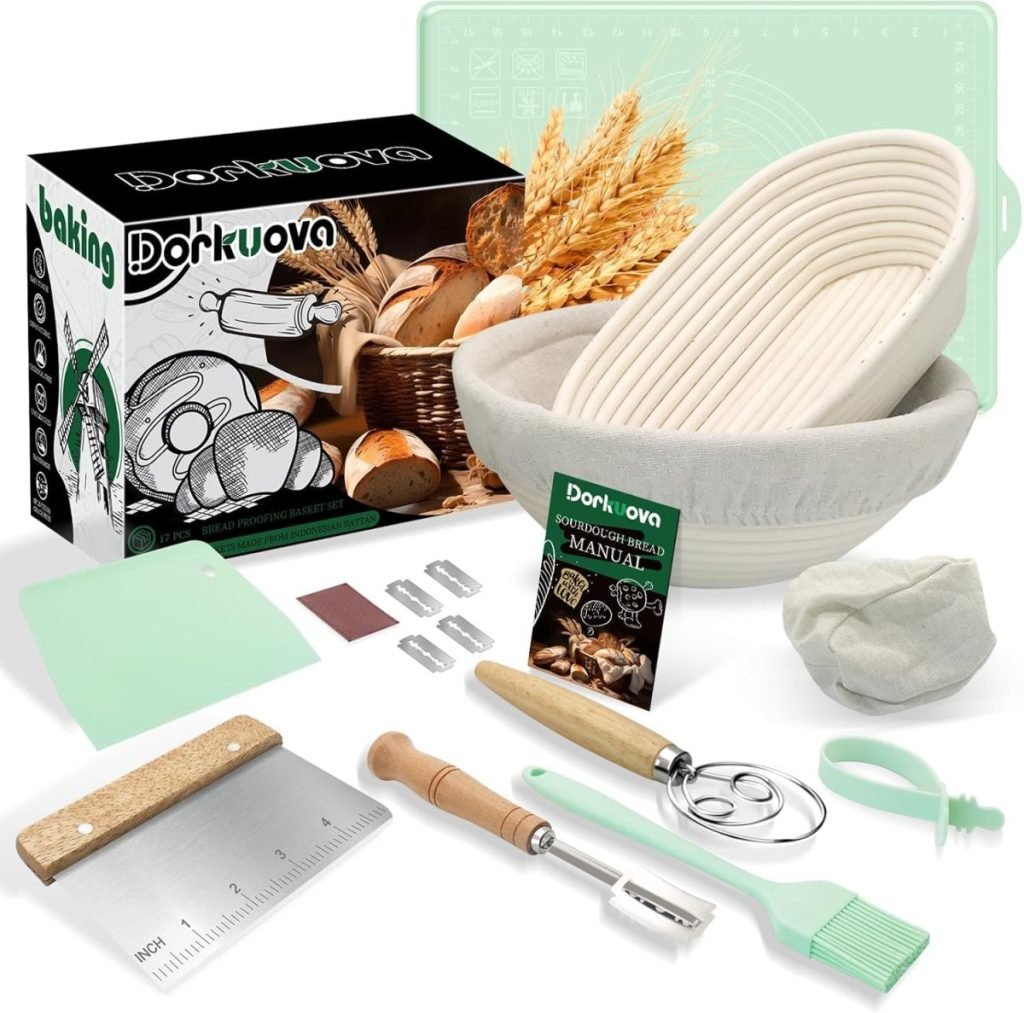 Baking kit with bowl, scraper, dough whisk, razor, scoring blades, brush, and bread-making manual. Box and ingredients like flour and wheat are visible.