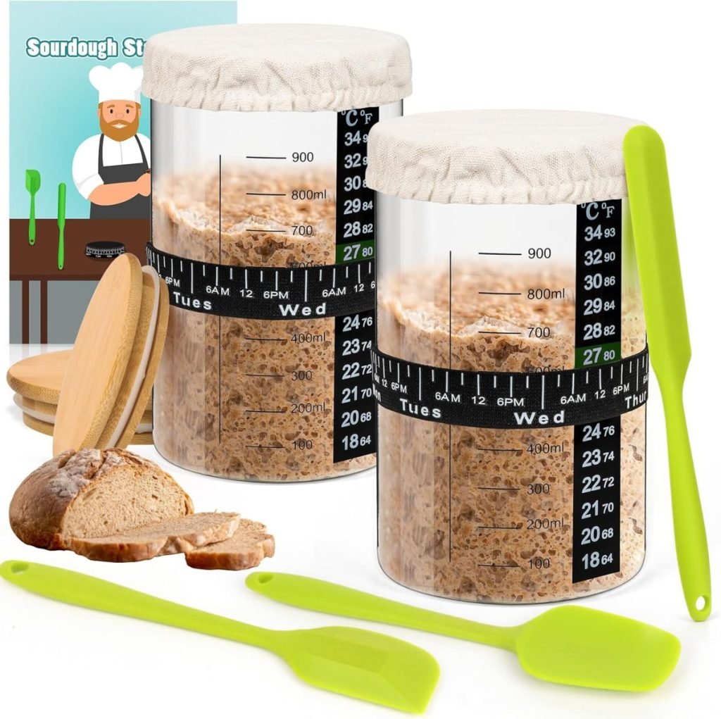 Two sourdough starter jars with measurement markings, accompanied by green spatulas, wooden spoons, a loaf of bread, and a backdrop with a chef illustration labeled "Sourdough Starter.