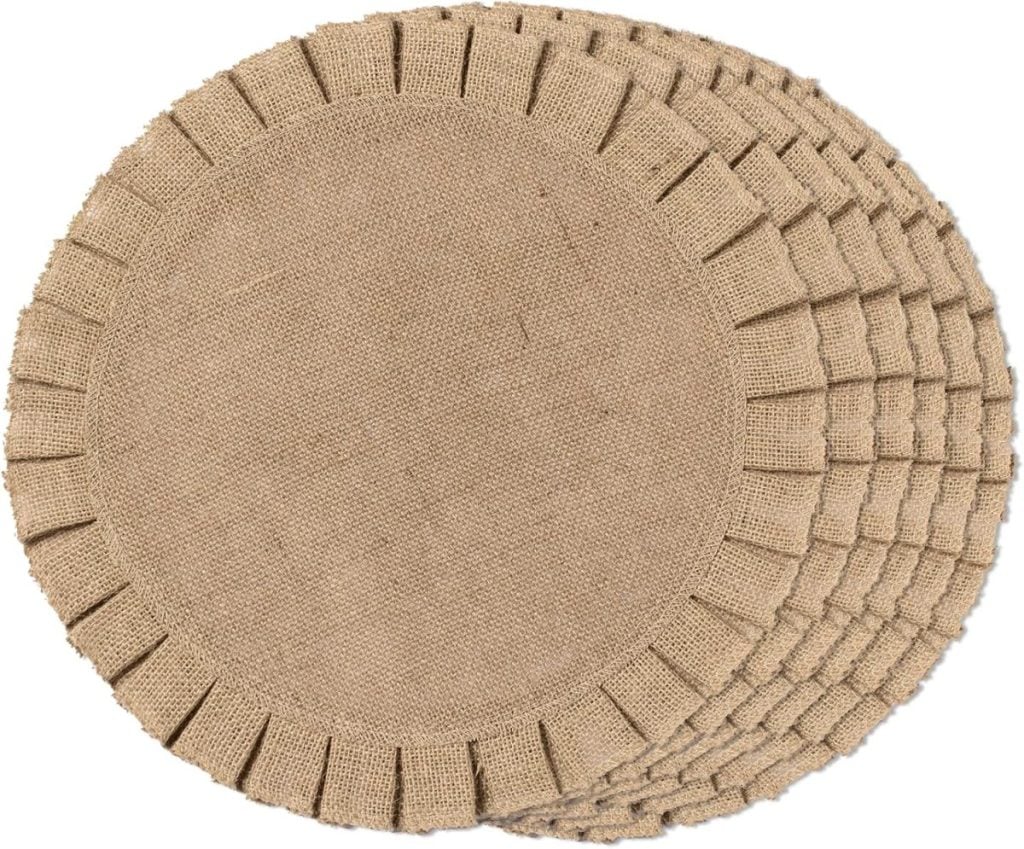 A stack of round burlap placemats with frayed edges sits ready to complement your Thanksgiving plates, arranged in a charming circular pattern.