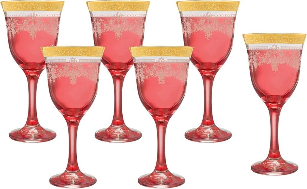 Six ornate, red wine glasses with gold and white decorative patterns are arranged in two rows, perfectly complementing the elegance of your Thanksgiving plates.