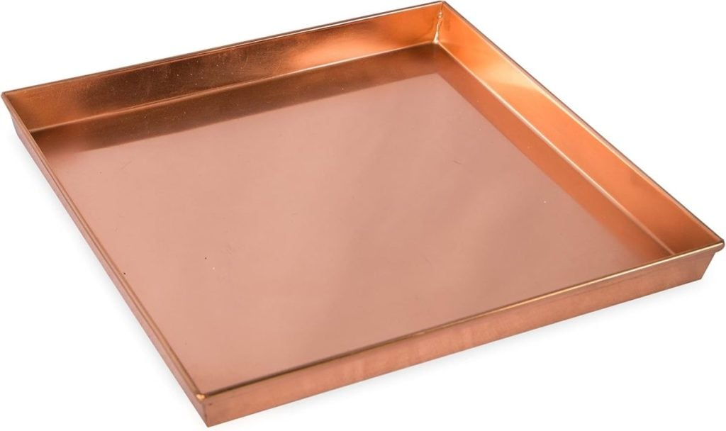 Square copper tray with raised edges, viewed at a slight angle.