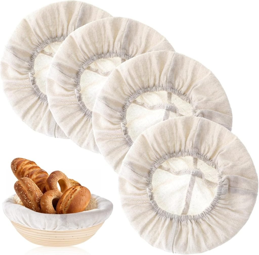 Four linen bread bowl covers are displayed above a basket filled with assorted bread rolls.