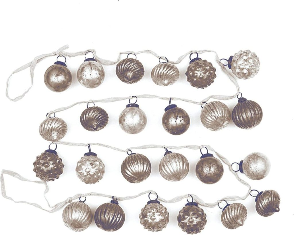 A garland of various textured and metallic silver and bronze ornaments arranged in rows on a white background.