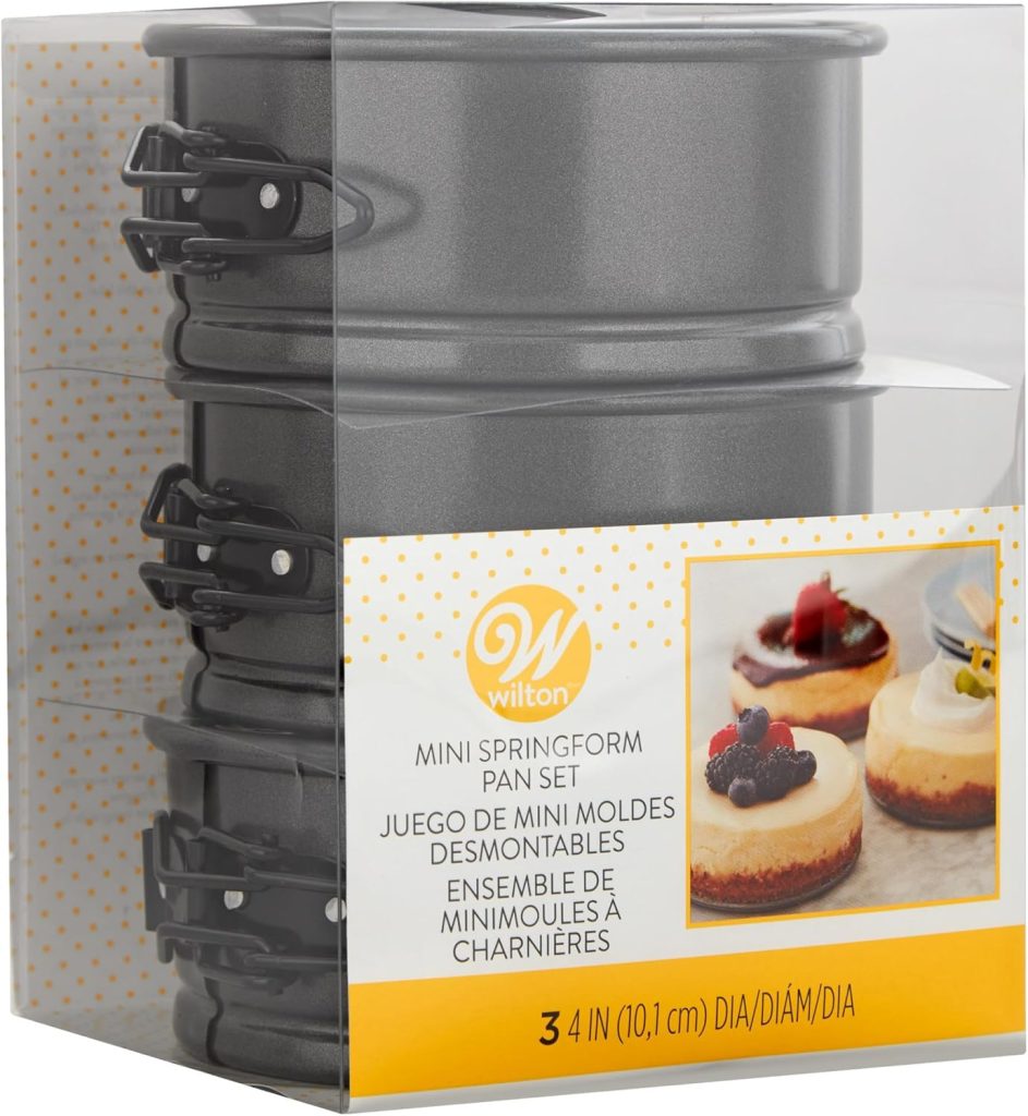 A set of four Wilton mini springform pans in packaging, perfect for baking delightful desserts for your Friendsgiving ideas. Featuring mouthwatering treats on the label, these pans will inspire you to create and share sweet moments with friends during the festive season.