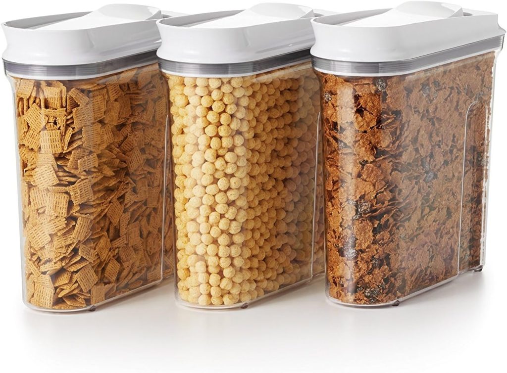 Three transparent containers filled with different cereals: squares, round puffs, and flakes, each topped with a white lid. Perfectly organized for your kitchen pantry, these cereal containers could soon be yours with the convenience of Amazon Prime delivery.