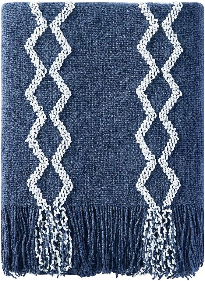 A dark blue textured blanket with white zigzag patterns and fringed ends.