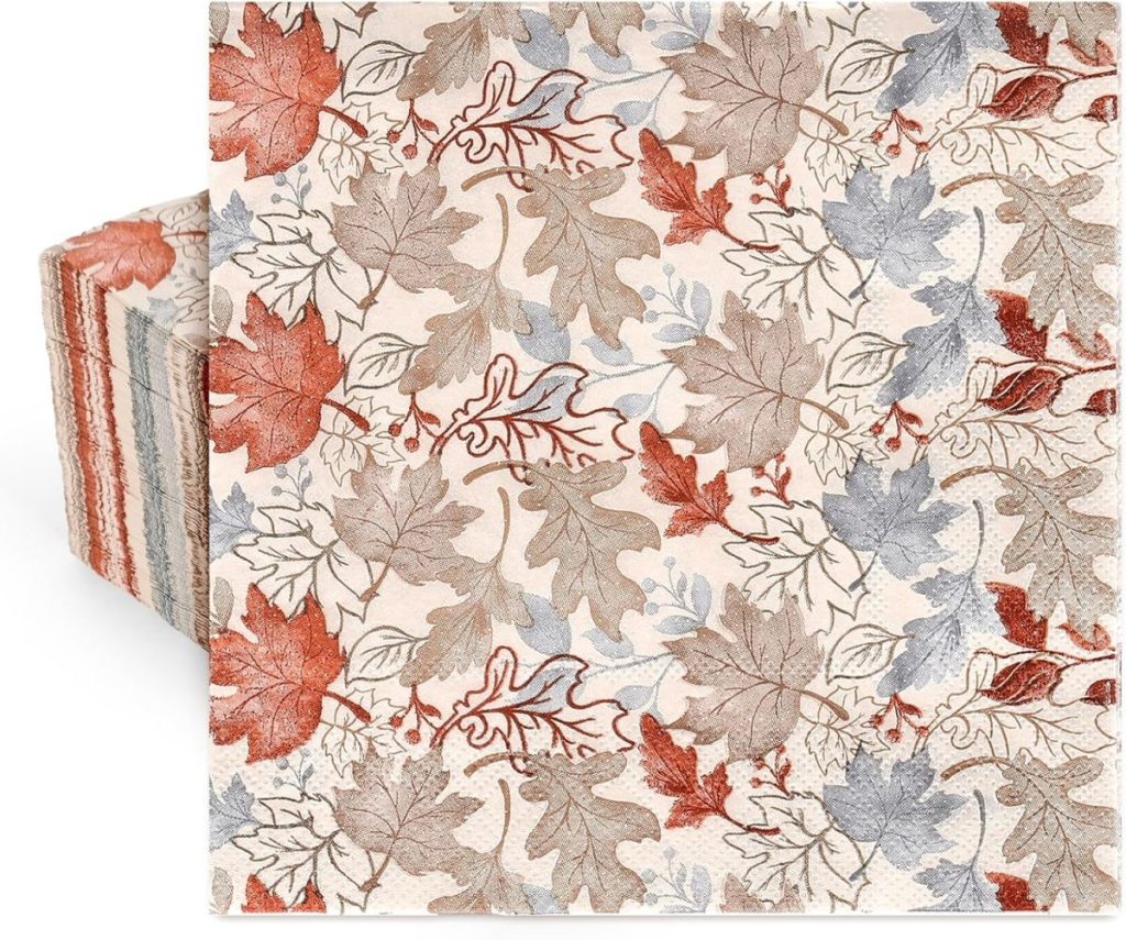 A stack of paper napkins with a pattern of autumn leaves in shades of brown, orange, and gray on a light background, perfect for your next pumpkin craft gathering.