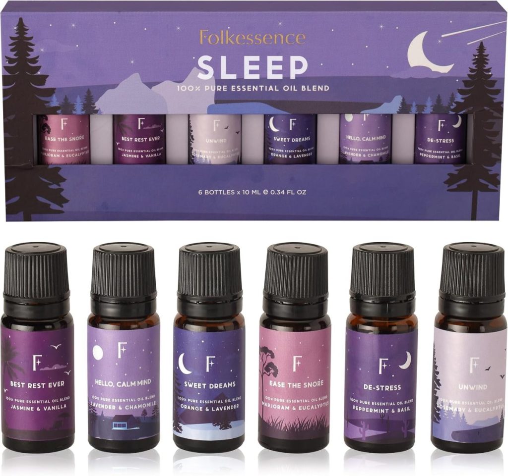 Six essential oil bottles with purple labels for sleep: Best Rest Ever, Hello Calm Mind, Sweet Dreams, Ease the Snore, De-Stress, and Unwind. Set against a matching themed box and available through Amazon Prime for swift delivery.