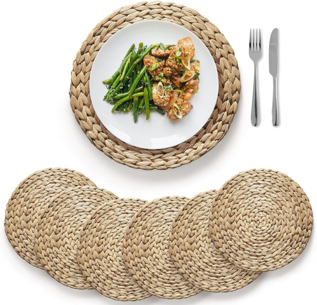 A plate of chicken and green beans rests on a woven placemat, evoking a cozy fall craft idea, surrounded by matching placemats, with a fork and knife neatly placed at the side.