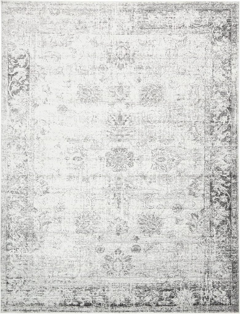 Faded decorative rug with intricate floral patterns in shades of gray and white, perfect for adding a touch of elegance to your Airbnb in Waco.