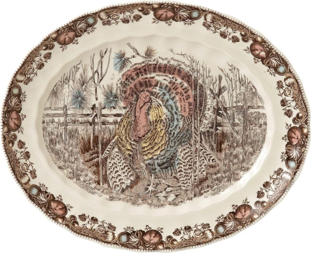 Ornate ceramic platter featuring a painted turkey in a rural setting, surrounded by a decorative border with floral and foliage motifs—perfect for serving at festive gatherings and inspiring Friendsgiving ideas.