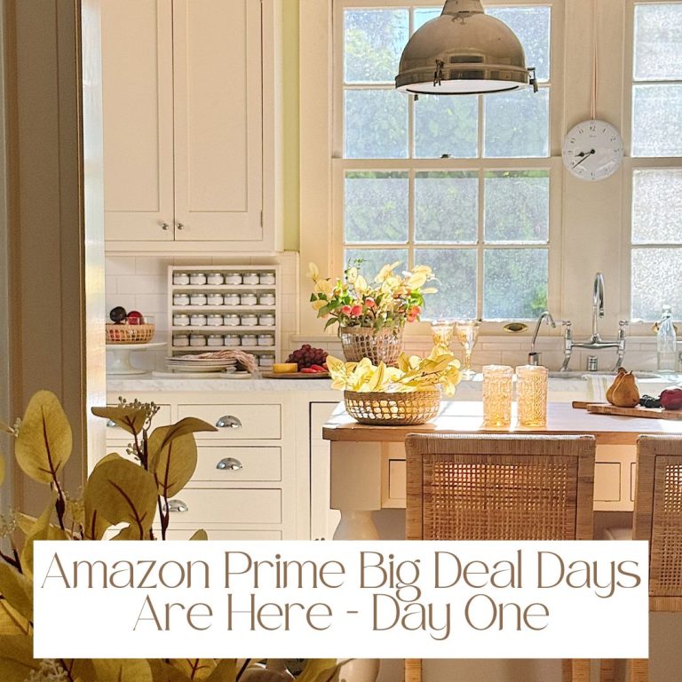 A bright kitchen with a wooden island, wicker chairs, fruit basket, and glass jars exudes warmth. A banner proudly announces, "Amazon Prime Big Deal Days Are Here - Day One," inviting excitement and fantastic finds into the heart of your home.