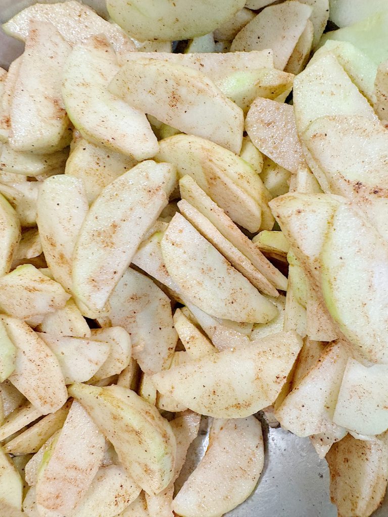 Sliced apples coated with cinnamon and sugar.