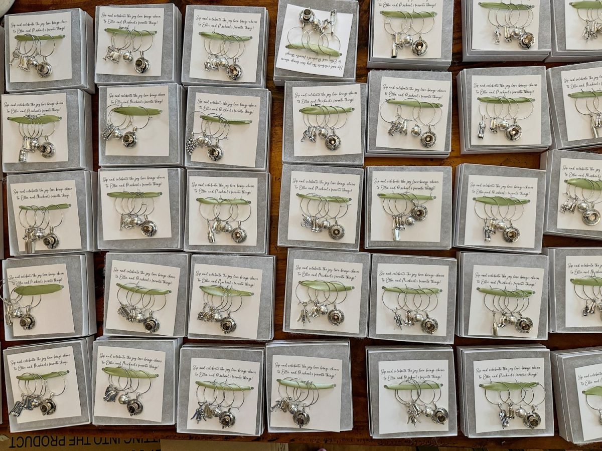 Rows of boxed sets of silver earrings with cards displaying text, arranged on a wooden surface.