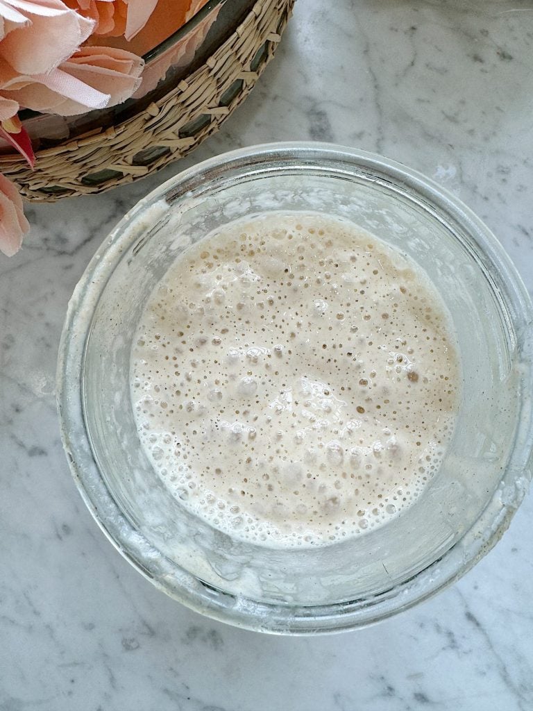 Bubbly sourdough starter, in a glass jar.