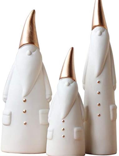 Three minimalist gnome figurines with white bodies and gold pointed hats, reminiscent of Christmas colors, stand in varying heights.