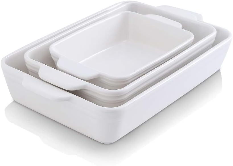 A set of four nested, white rectangular ceramic baking dishes with handles on a white background, perfect for preparing holiday desserts.