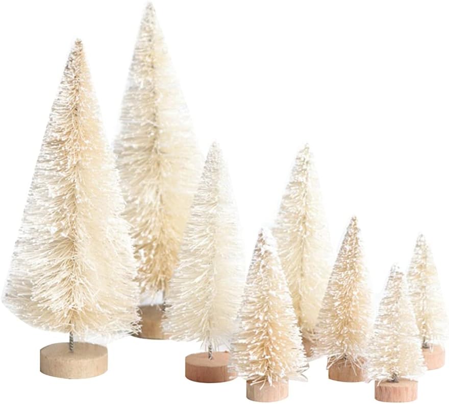 Seven small, white bottle brush trees of varying heights with wooden bases are arranged together, infused with Christmas colors to bring a festive touch.