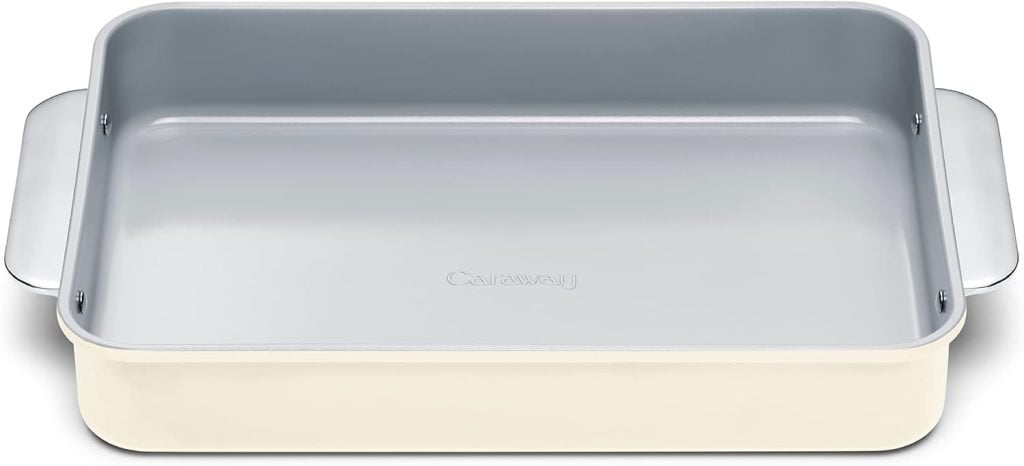 A rectangular beige baking pan with handles on both sides, perfect for holiday desserts. The interior is gray, featuring the brand name "Caraway" embossed at the center.