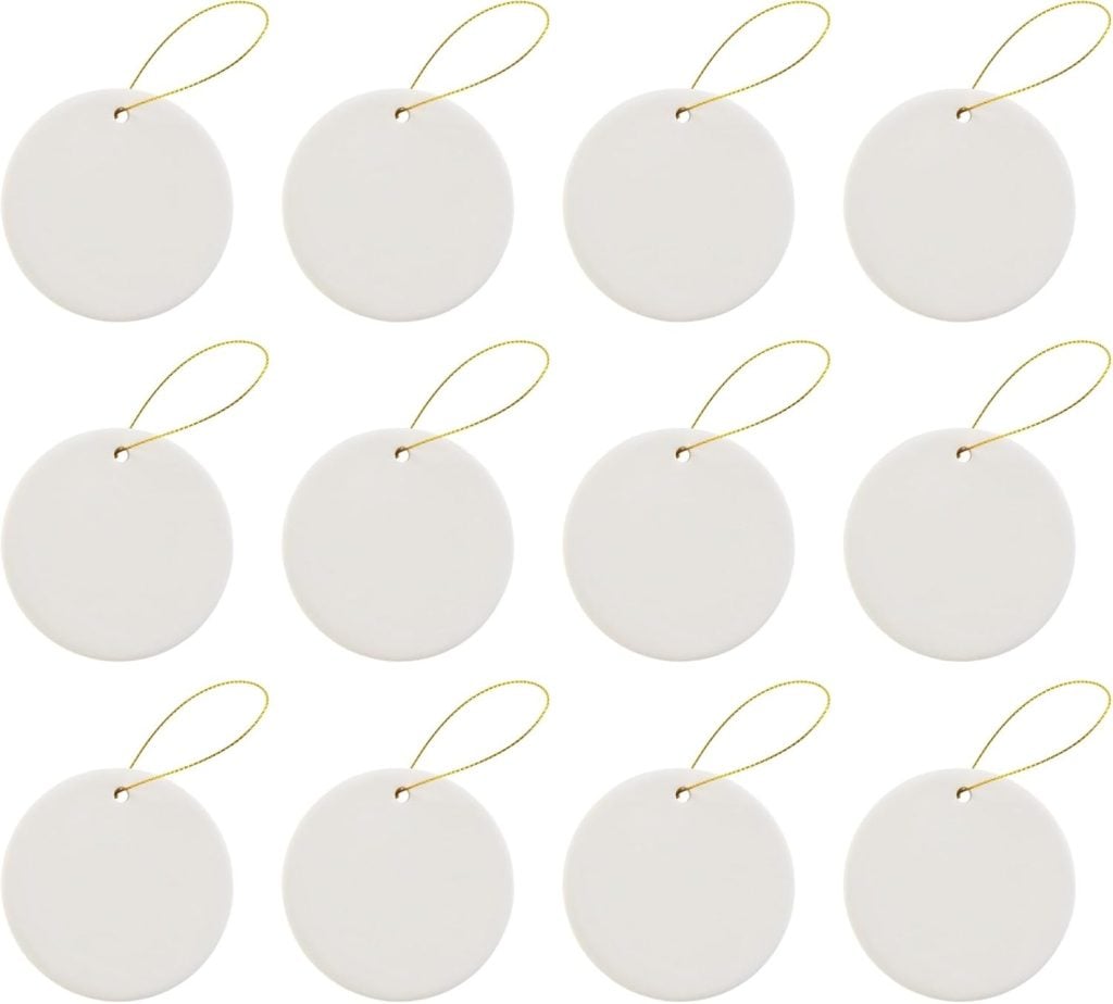 Twelve pristine oyster shell-inspired white round ornaments with gold hanging strings are elegantly arranged in rows.