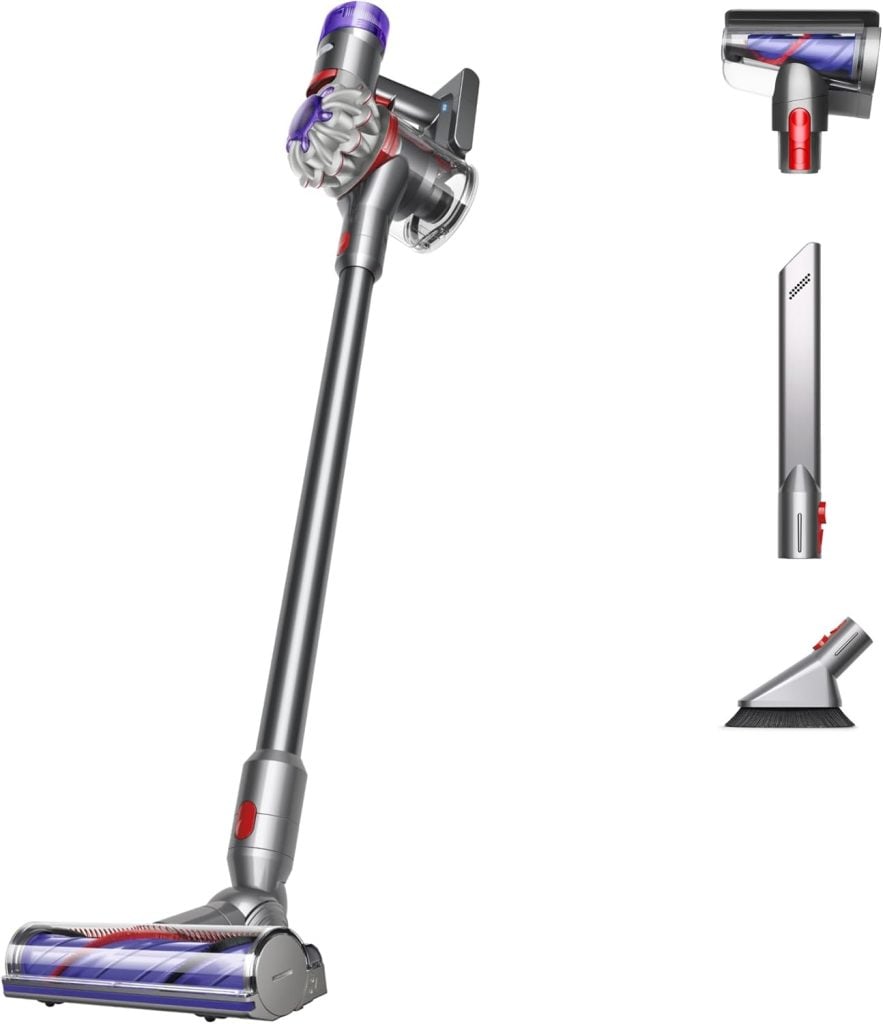 Cordless vacuum cleaner with attachments, including a crevice tool and brush.