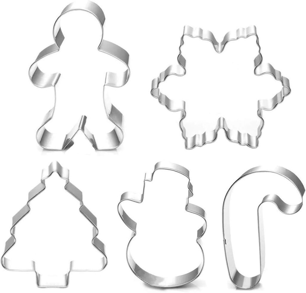 Five metal cookie cutters designed for crafting holiday desserts, featuring shapes like a gingerbread person, snowflake, tree, snowman, and candy cane.