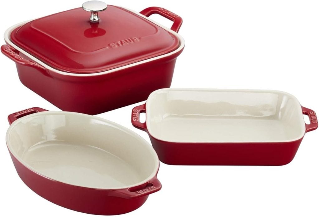 Three red ceramic baking dishes are shown: one oval, one rectangular, and one square with a lid. Perfect for Black Friday shopping, these versatile pieces enhance any kitchen collection.