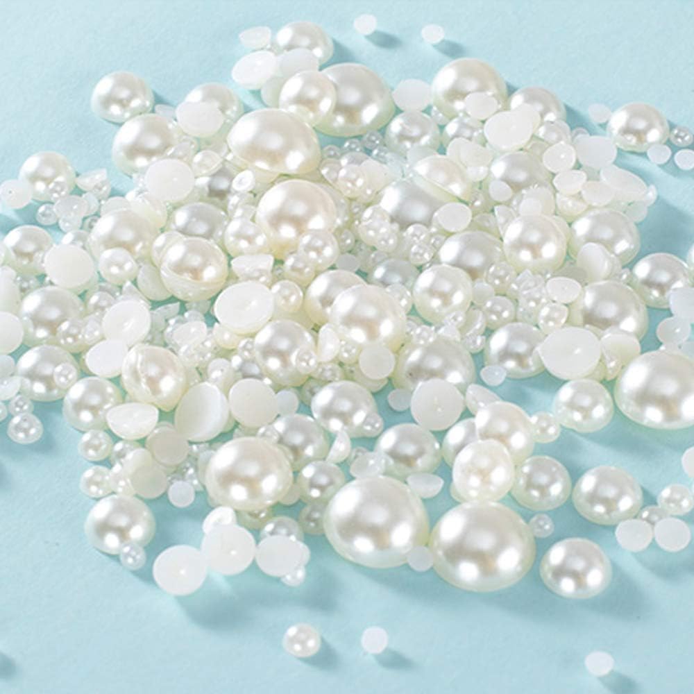 A collection of various-sized white pearls scattered on a light blue surface.