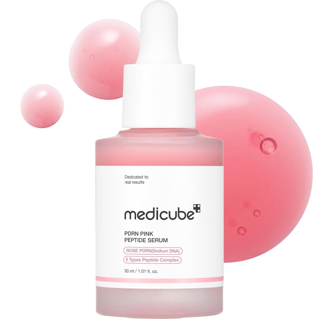 A bottle of Medicube PDRN Pink Peptide Serum with a dropper cap, displayed alongside pink liquid droplets on a white background—perfect for adding to your skincare routine this Black Friday.