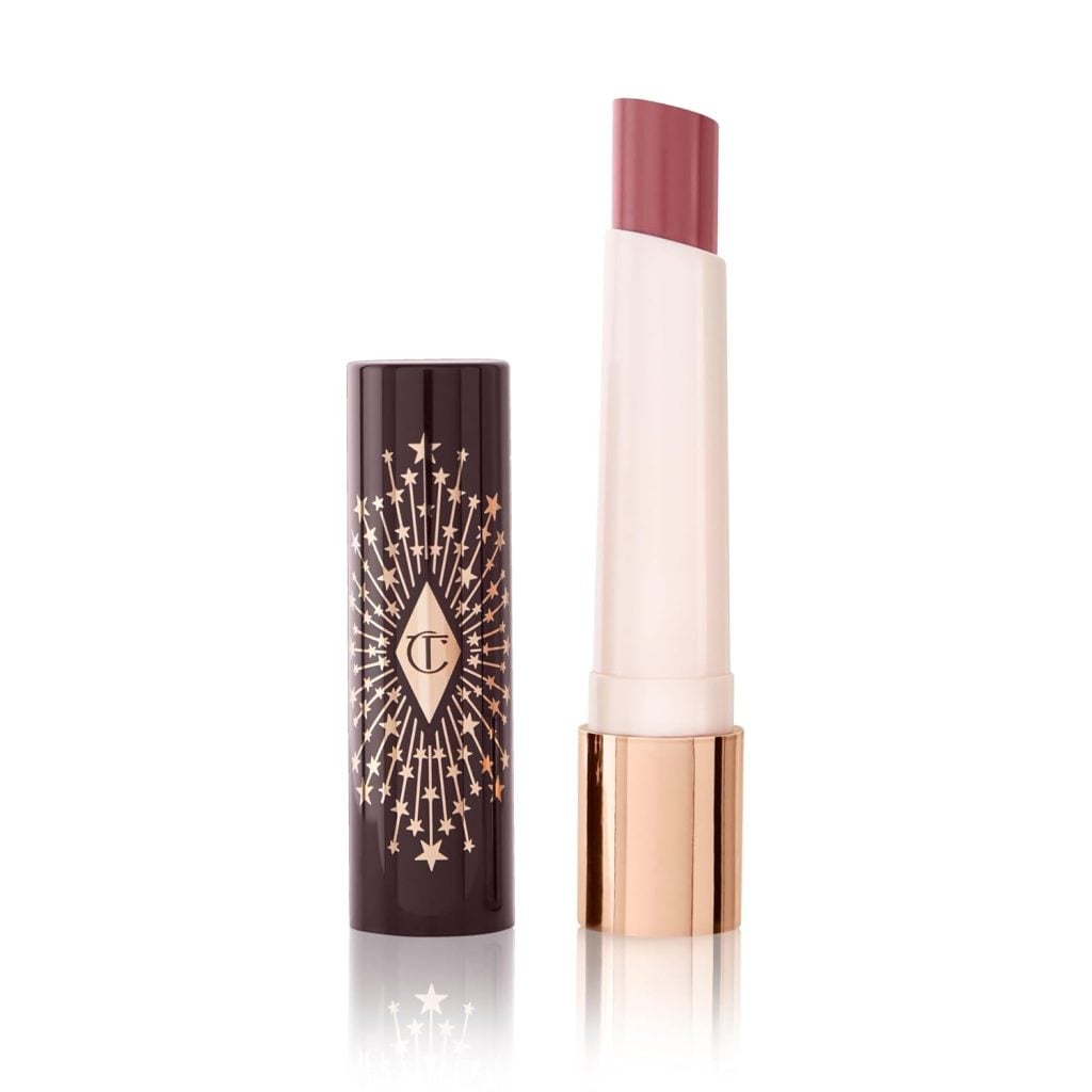 A lipstick with a mauve shade in a slim white and gold tube, shown with its decorative black and gold cap standing upright beside it—perfect for capturing the charm of Christmas Morning.