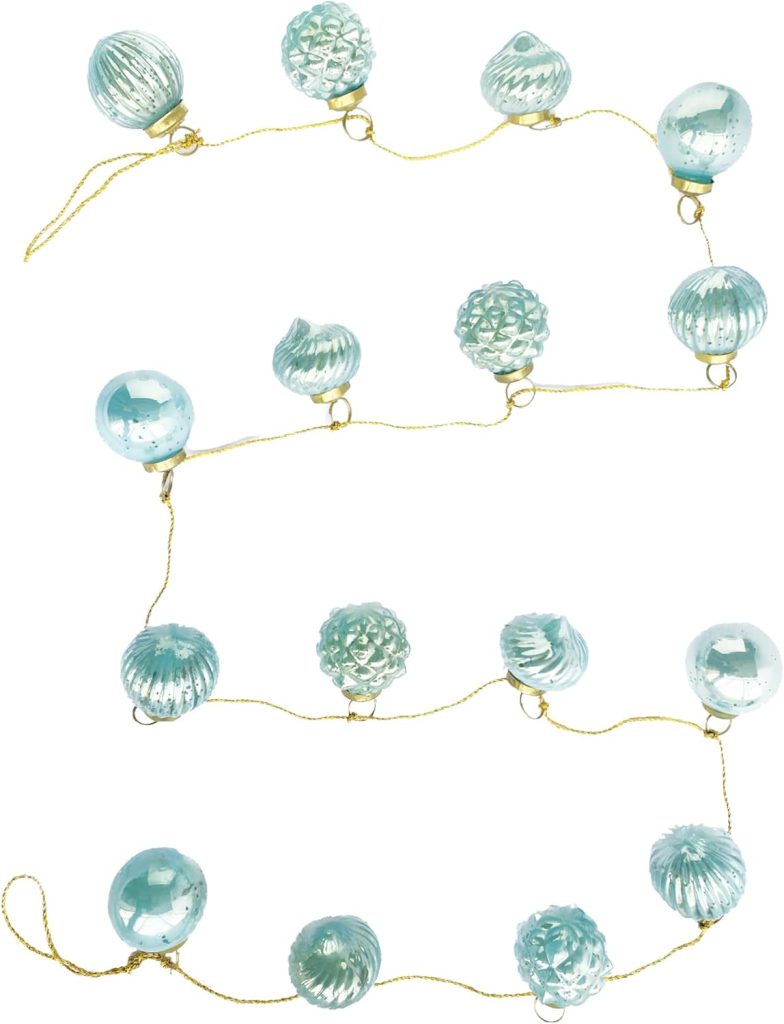 A string of blue glass ornaments with various textured patterns, reminiscent of oyster shell designs, connected by a thin gold cord and arranged in a loose zigzag pattern.