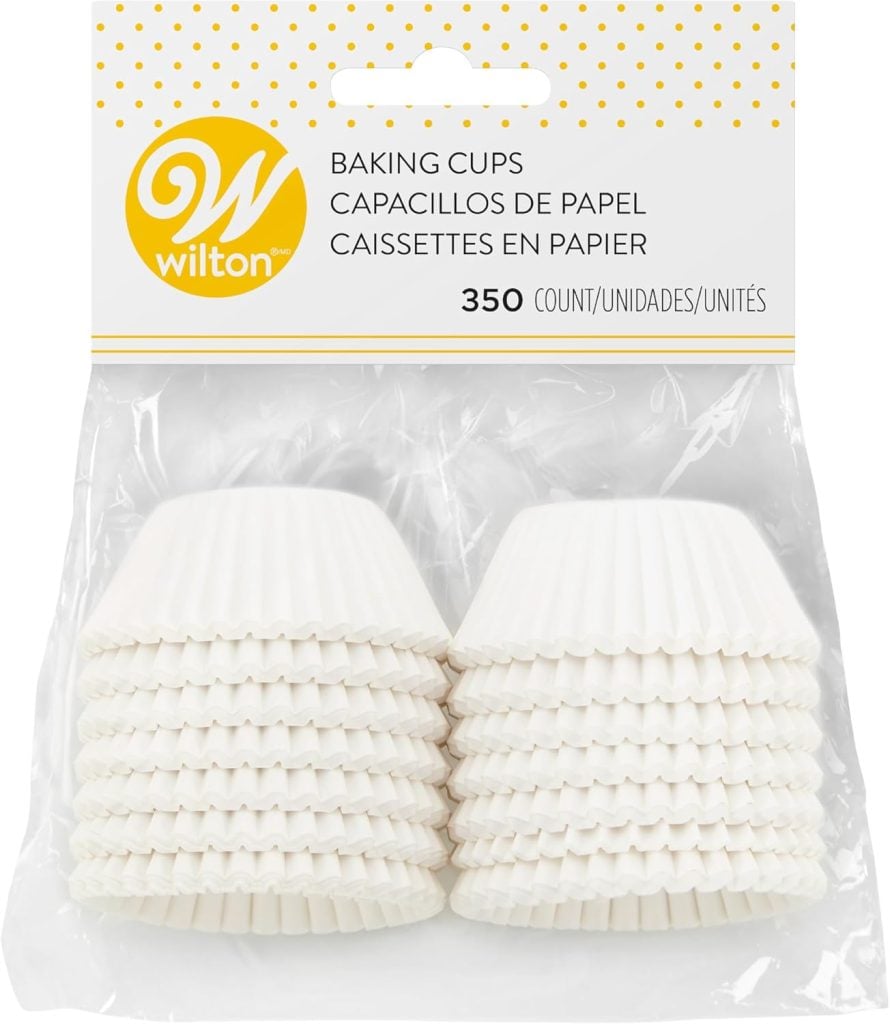 Pack of 350 white paper baking cups in a plastic package, perfect for creating delightful Christmas tree cupcakes, with Wilton branding at the top.