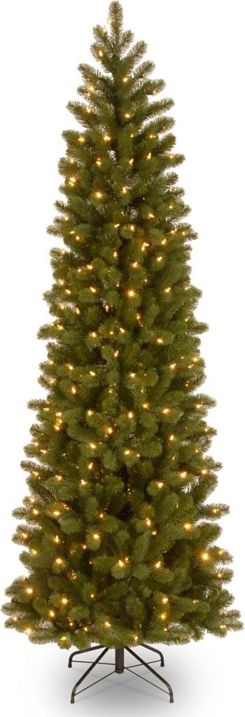 A tall, artificial Christmas tree with warm white lights on a metal stand is the perfect centerpiece for your festive Black Friday deals.