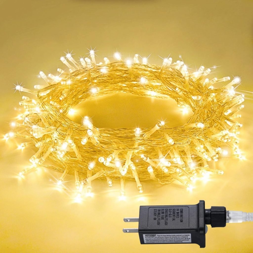 A coil of warm white LED string lights with a black plug is displayed on a yellow background.