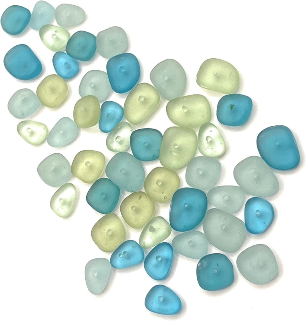 A collection of smooth, multicolored sea glass pieces in shades of blue, green, and amber, scattered on a white background.