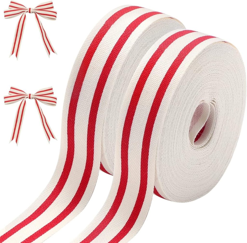 Two rolls of white fabric ribbon with red stripes, perfect for gift wrapping, alongside two tied bows of the same design.