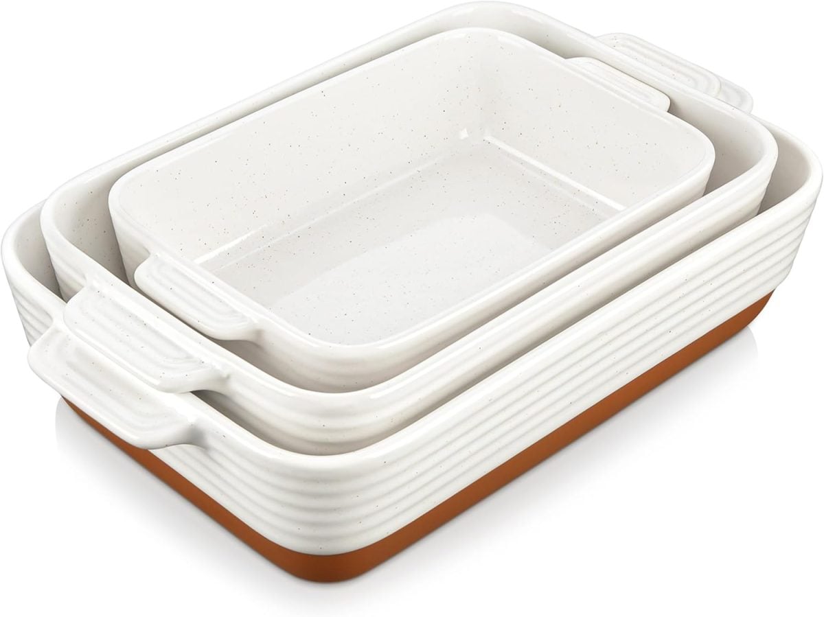 Three white ceramic baking dishes of varying sizes are nested together, each with side handles and a brown base—perfect for serving your favorite holiday desserts.
