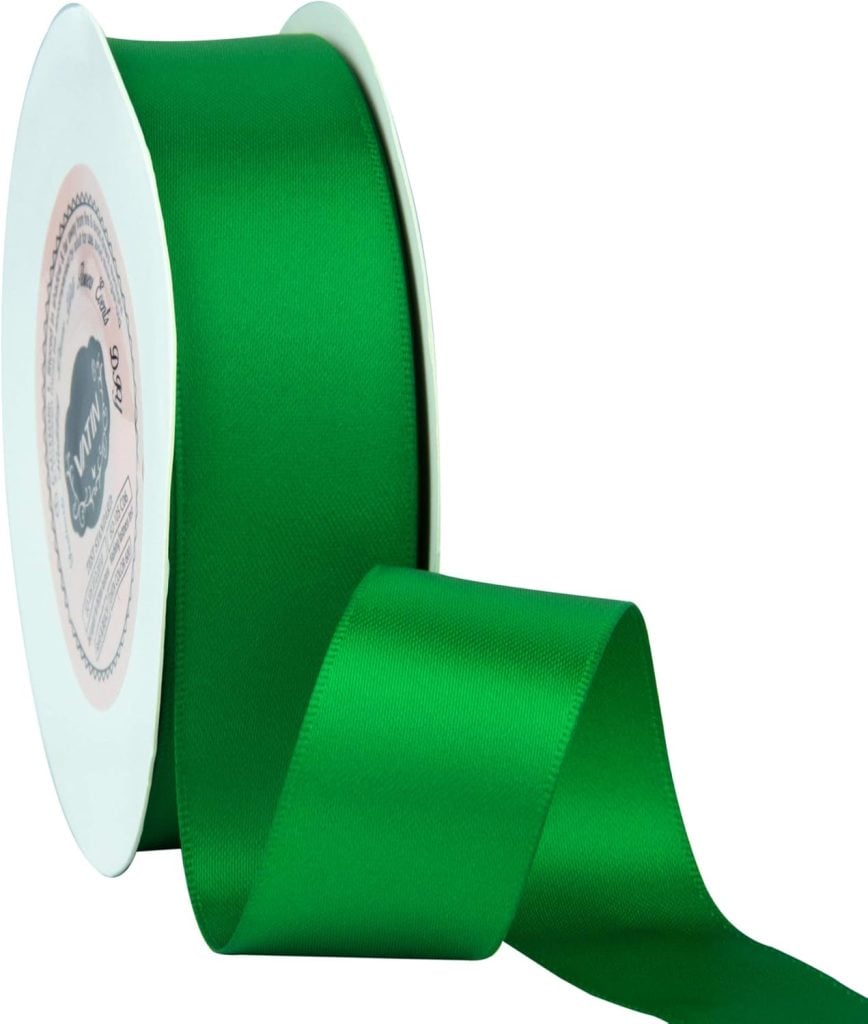 A roll of green satin ribbon, perfect for gift wrapping, partially unspooled with a white circular holder.