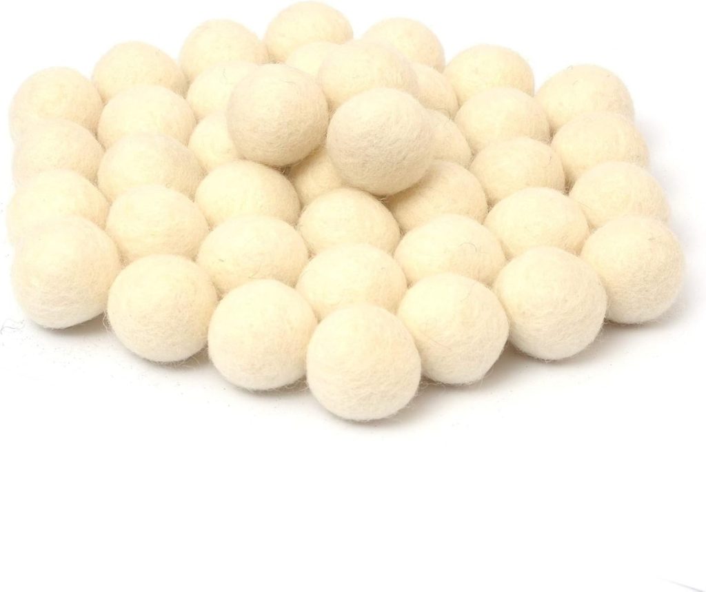 A charming arrangement reminiscent of a cozy Christmas tree skirt, this pile of white wool dryer balls exudes warmth and comfort, perfectly clustered together.