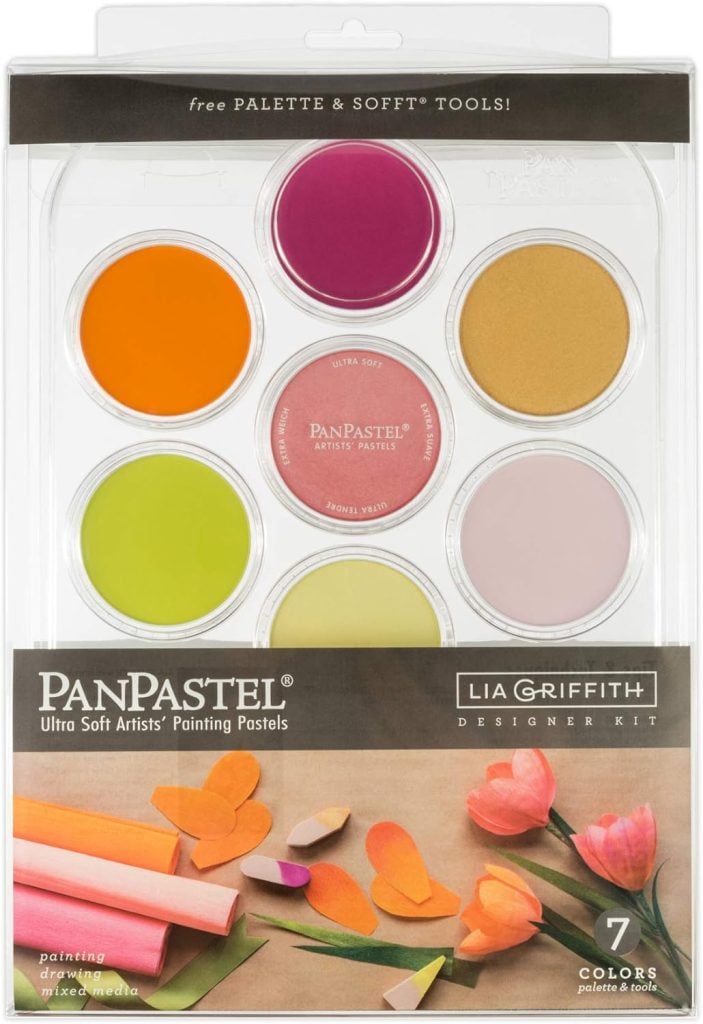 The PanPastel Lia Griffith Designer Kit features seven ultra-soft painting pastels in various colors, perfect for crafting vibrant designs. Displayed in clear packaging alongside paper flowers, this kit is an ideal companion for creating a festive Christmas wreath masterpiece.