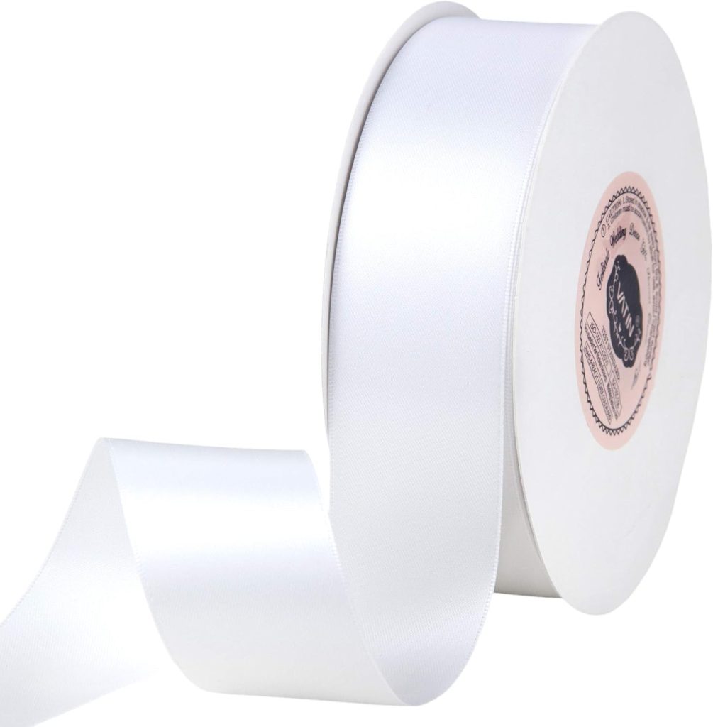 A spool of white satin ribbon with a soft sheen is partially unrolled, perfect for gift wrapping, displaying its smooth texture.