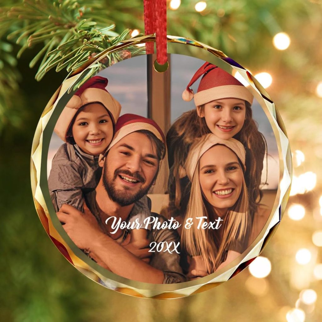 A family of four wearing Santa hats smiles for a photo on a round Christmas ornament. The text reads: "Your Photo & Text, 20XX." The ornament hangs on a tree.