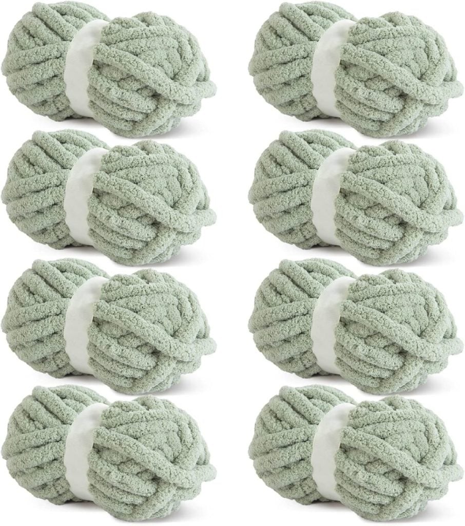 Eight skeins of soft, green yarn arranged in two vertical columns, perfect for crafting a cozy Christmas tree skirt.