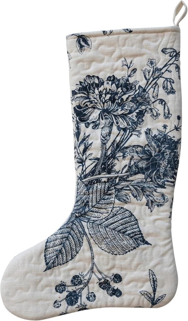 A fabric Christmas stocking with a navy blue floral and leaf pattern on an off-white background, perfect for adding charm to your Christmas morning.