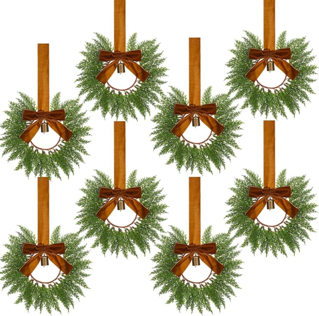 Eight identical green wreaths with brown ribbons and bells hang on vertical brown straps, arranged in two rows against a white background, showcasing classic Christmas colors.