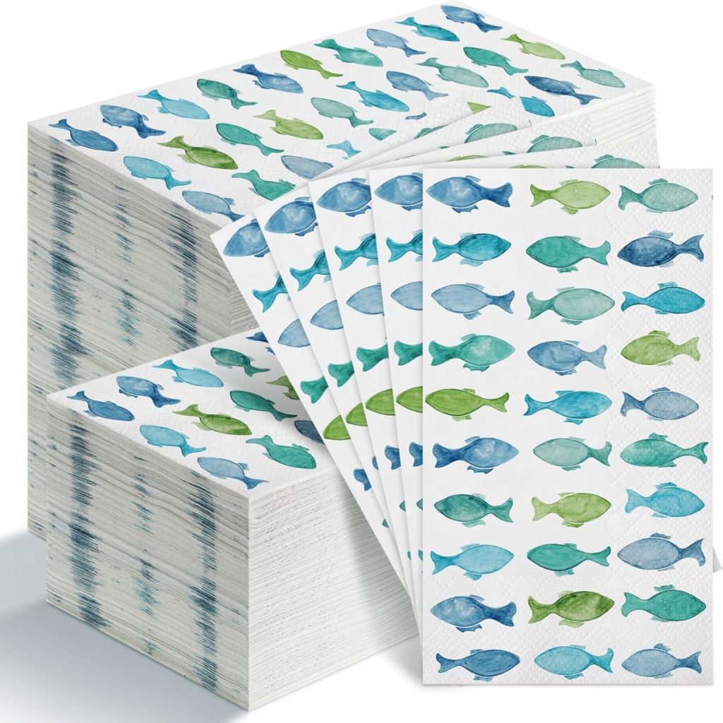 Stacks of paper napkins with a blue and green fish pattern.