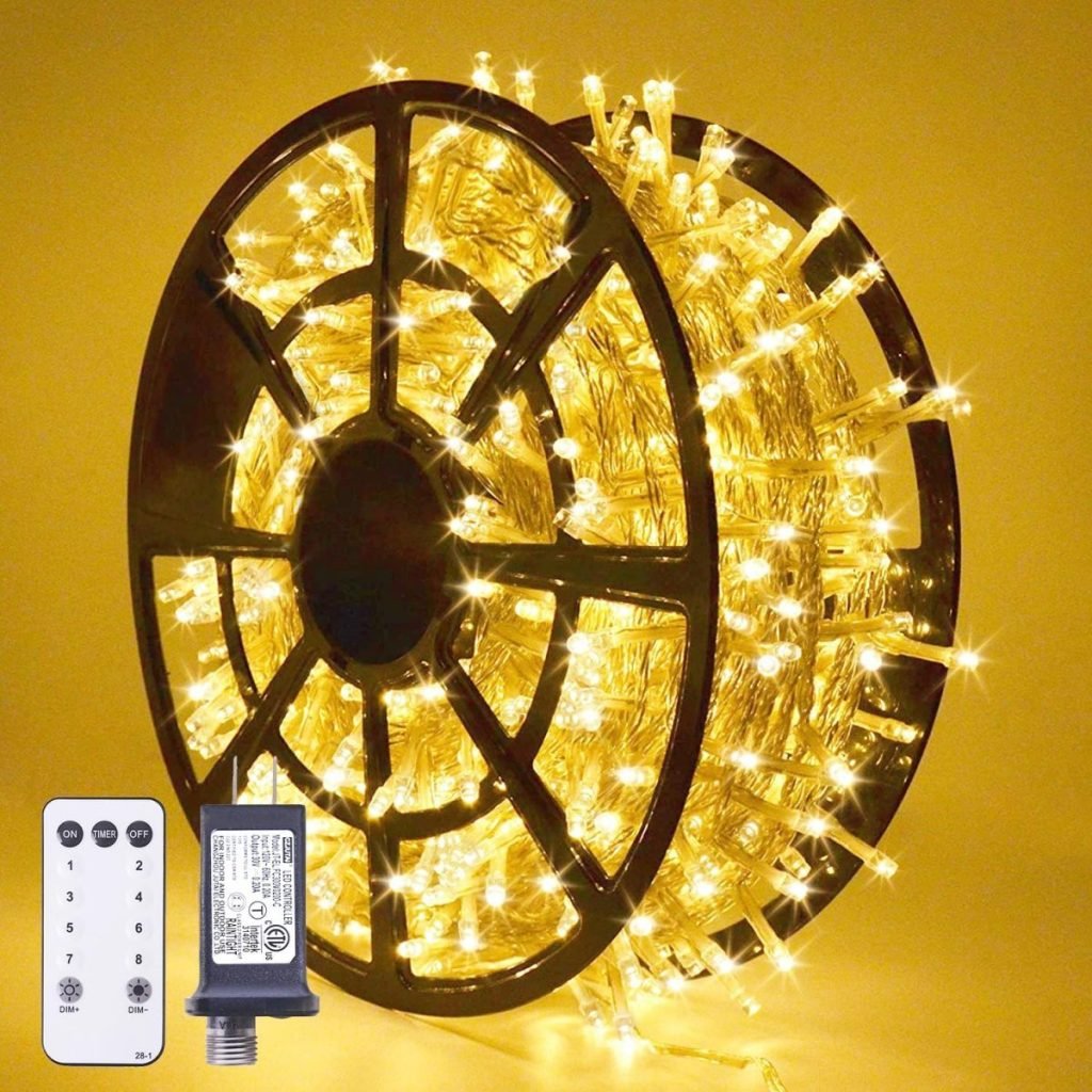 A spool of yellow LED string lights is displayed alongside a remote control and power adapter, set against a yellow background, evoking a festive nutcracker Christmas ambiance.